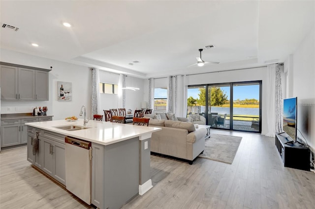 15865 Key Biscayne Ln, Loxahatchee, FL 33470 - kitchen featuring a sink, gray cabinetry, dishwasher, a raised ceiling, and a kitchen island with sink