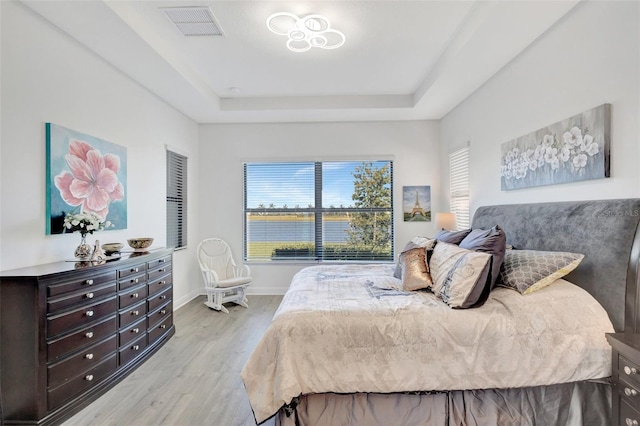 15865 Key Biscayne Ln, Loxahatchee, FL 33470 - bedroom with a tray ceiling, light wood finished floors, and baseboards