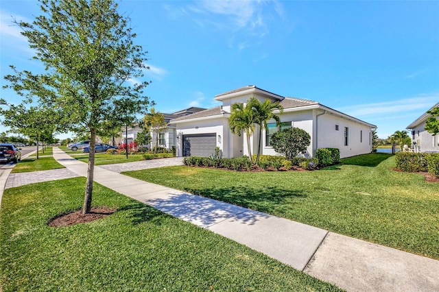 15865 Key Biscayne Ln, Loxahatchee, FL 33470 - mediterranean / spanish home with driveway, a front yard, an attached garage, and stucco siding