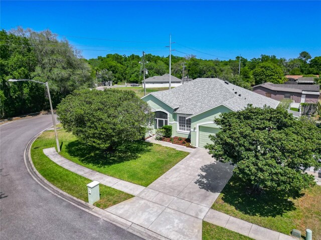 1157 Valley Creek Run, Winter Park, FL 32792 - view of front facade with an attached garage, driveway, roof with shingles, and a front lawn