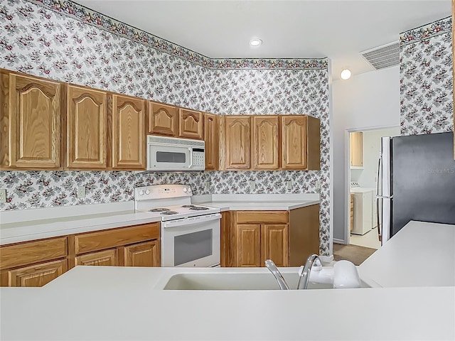 1157 Valley Creek Run, Winter Park, FL 32792 - kitchen featuring a sink, washer / clothes dryer, white appliances, and wallpapered walls