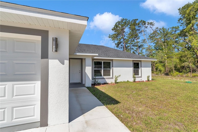 17468 SW 36th Ter, Ocala, FL 34473 - view of front of property featuring a garage, a front yard, roof with shingles, and stucco siding
