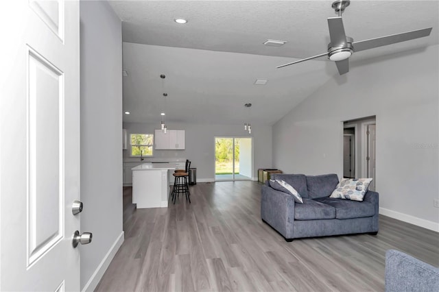 17468 SW 36th Ter, Ocala, FL 34473 - living room with light wood-type flooring, baseboards, vaulted ceiling, and ceiling fan