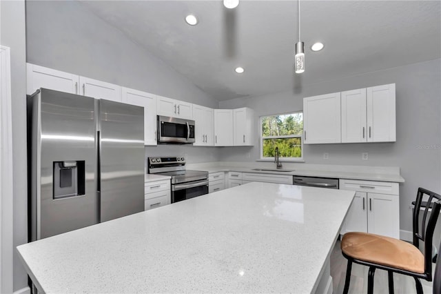 17468 SW 36th Ter, Ocala, FL 34473 - kitchen with white cabinetry, a center island, a sink, lofted ceiling, and stainless steel appliances