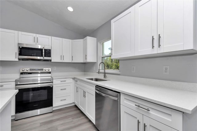17468 SW 36th Ter, Ocala, FL 34473 - kitchen with stainless steel appliances, light countertops, vaulted ceiling, and a sink
