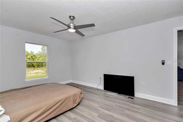 17468 SW 36th Ter, Ocala, FL 34473 - bedroom featuring a textured ceiling, wood finished floors, ceiling fan, and baseboards