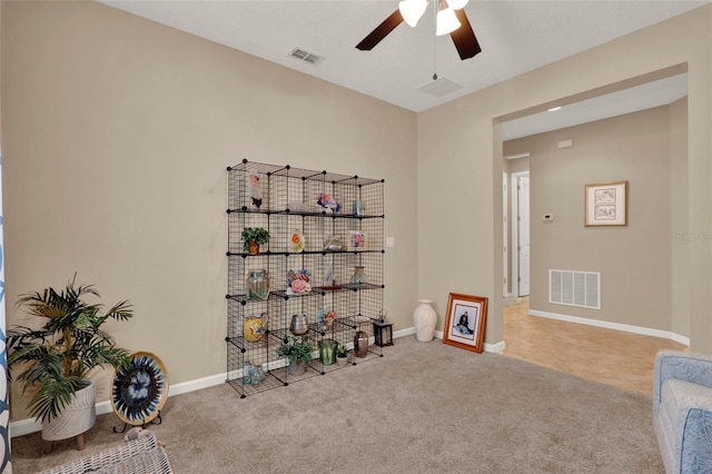 interior space featuring visible vents, baseboards, a ceiling fan, and carpet floors