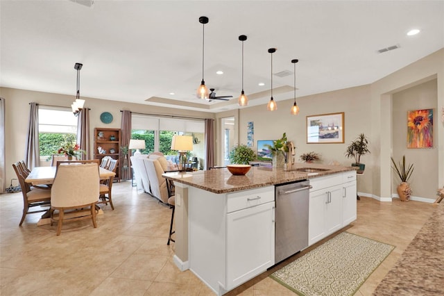 kitchen featuring light stone counters, white cabinetry, visible vents, dishwasher, and a sink