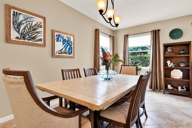 dining space featuring a chandelier and baseboards
