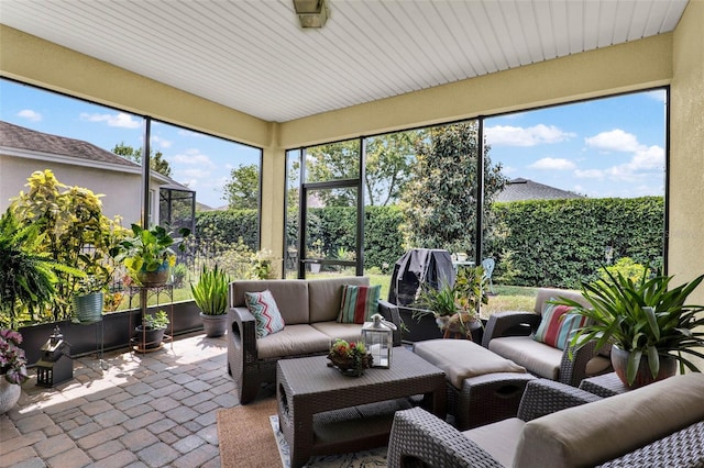 sunroom / solarium with an outdoor living space and brick floor