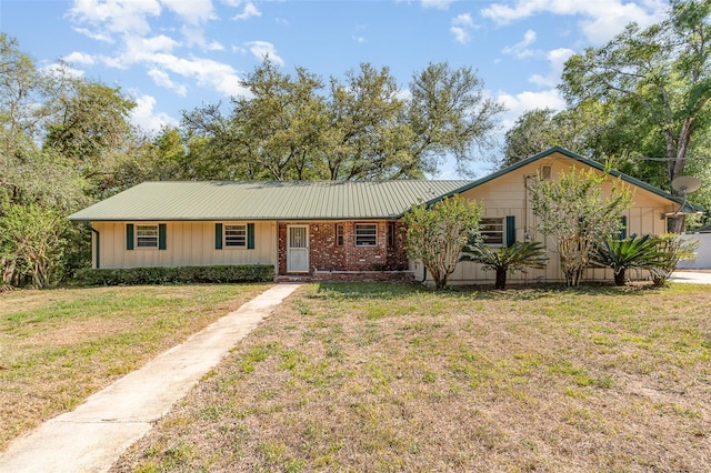 ranch-style home with metal roof and a front yard