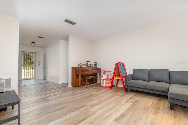 living area featuring baseboards, visible vents, and light wood-style flooring