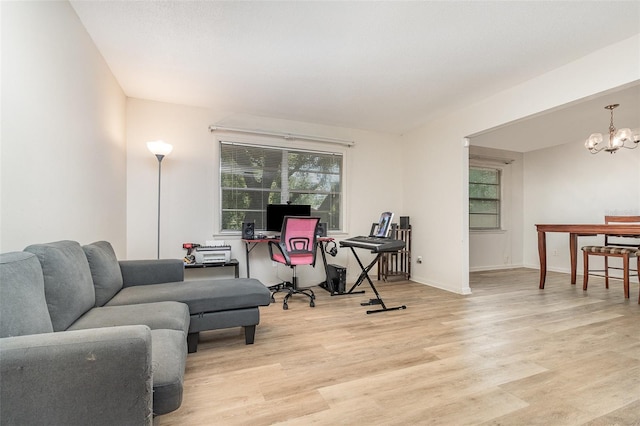 office featuring an inviting chandelier, light wood finished floors, and baseboards