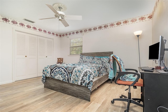 bedroom featuring a closet, wood finished floors, visible vents, and a ceiling fan