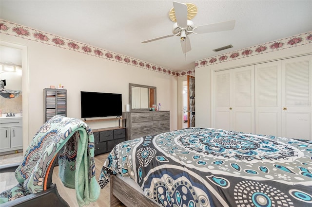 bedroom with a ceiling fan, wood finished floors, a sink, a closet, and visible vents
