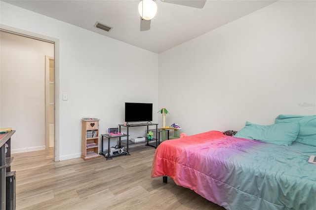 bedroom featuring light wood-type flooring, baseboards, a ceiling fan, and visible vents