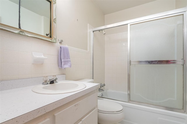 bathroom featuring vanity, shower / bath combination with glass door, and toilet