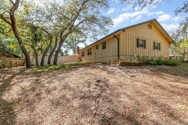 view of side of property with fence and board and batten siding