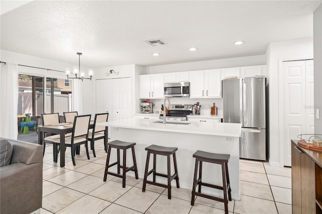 1415 Sherbourne St, Winter Garden, FL 34787 - kitchen featuring a kitchen bar, visible vents, a chandelier, light countertops, and stainless steel appliances