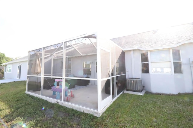 4217 Avanti Cir, New Port Richey, FL 34655 - rear view of property with central AC unit, a lawn, glass enclosure, a patio, and stucco siding