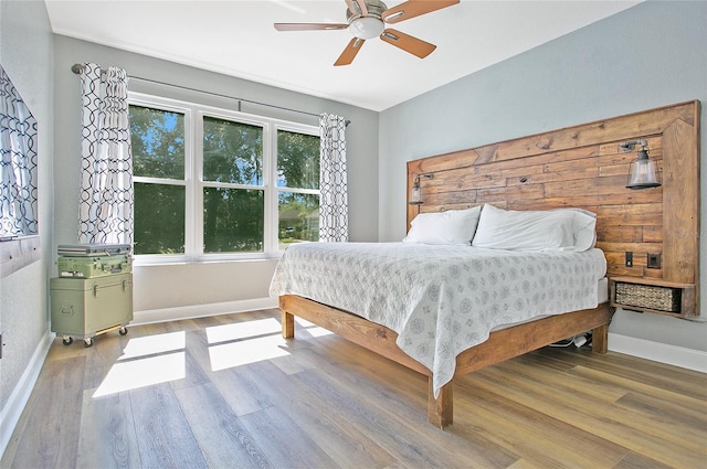 bedroom with wood finished floors, baseboards, and a ceiling fan