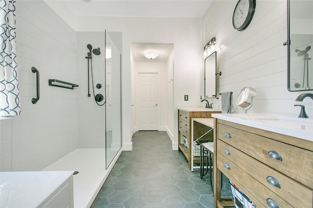 full bathroom with a sink, tile patterned floors, a tile shower, and two vanities