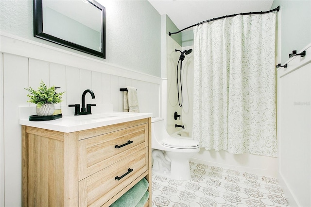 full bathroom with shower / bath combo with shower curtain, vanity, a wainscoted wall, and toilet