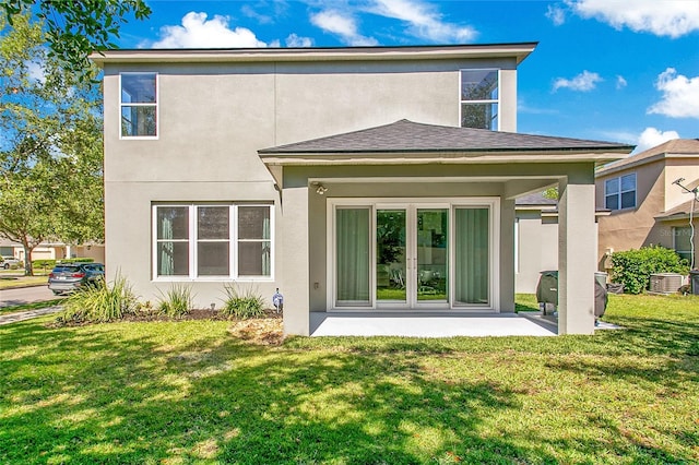 back of house with a patio, a lawn, and stucco siding
