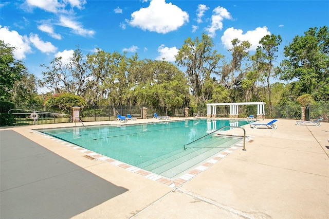 community pool featuring fence and a patio
