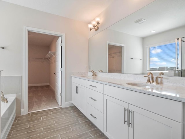 16195 Point Rock Dr, Winter Garden, FL 34787 - full bathroom with a sink, a walk in closet, double vanity, and wood finished floors