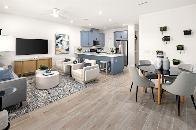 living area with recessed lighting, light wood-style flooring, visible vents, and a ceiling fan
