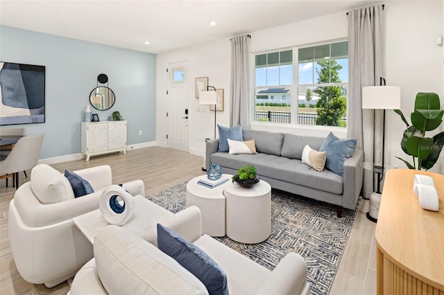 living area with light wood-style flooring, baseboards, and recessed lighting