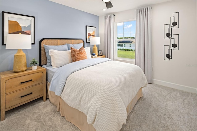 bedroom featuring light carpet, baseboards, and ceiling fan