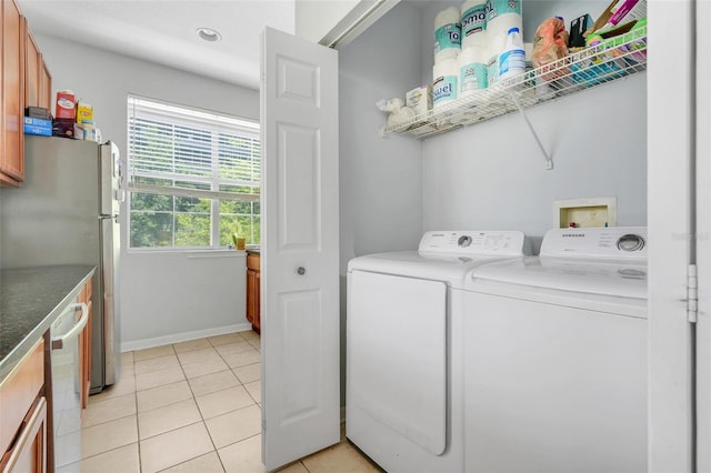laundry room featuring light tile patterned floors, baseboards, laundry area, and washer and dryer