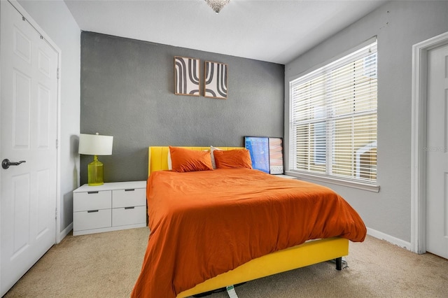 bedroom featuring baseboards and light colored carpet