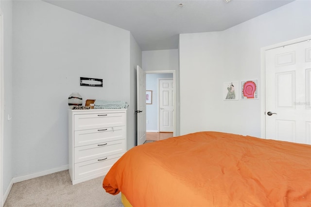bedroom with light colored carpet and baseboards