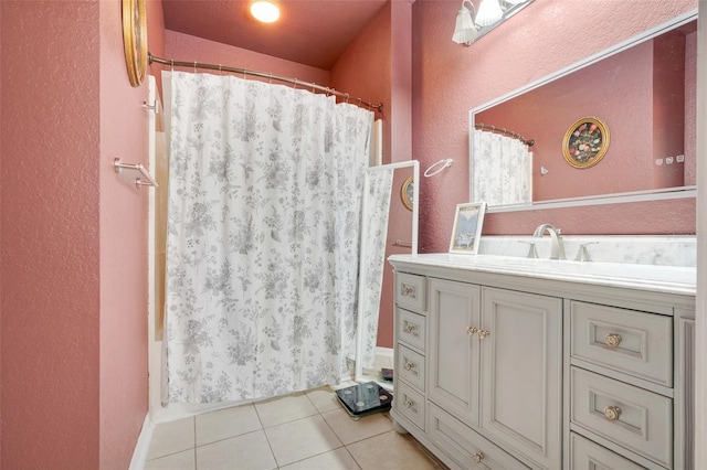 full bathroom with vanity, a textured wall, tile patterned floors, and curtained shower
