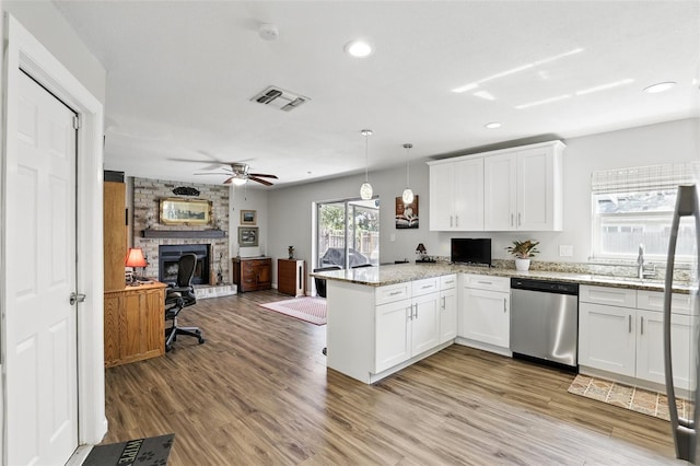kitchen featuring open floor plan, dishwasher, a peninsula, white cabinetry, and visible vents