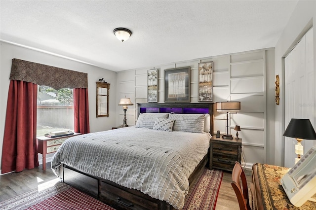 bedroom featuring wood finished floors and a textured ceiling
