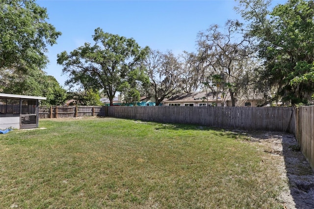 view of yard with a fenced backyard and a sunroom