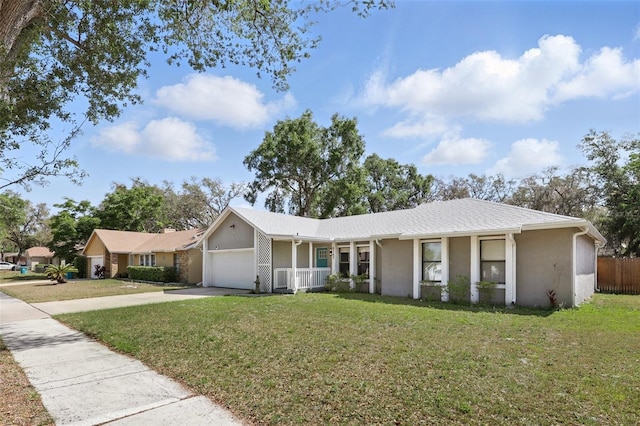 ranch-style home featuring driveway, an attached garage, a porch, a front yard, and stucco siding