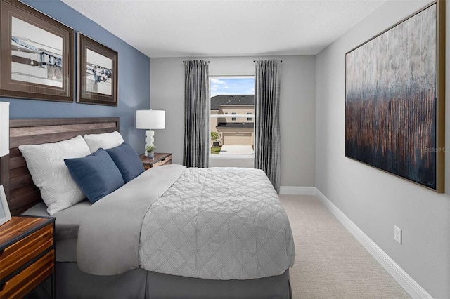 bedroom with baseboards and carpet
