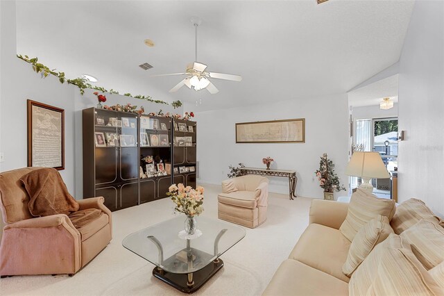 carpeted living area featuring visible vents, a ceiling fan, and vaulted ceiling