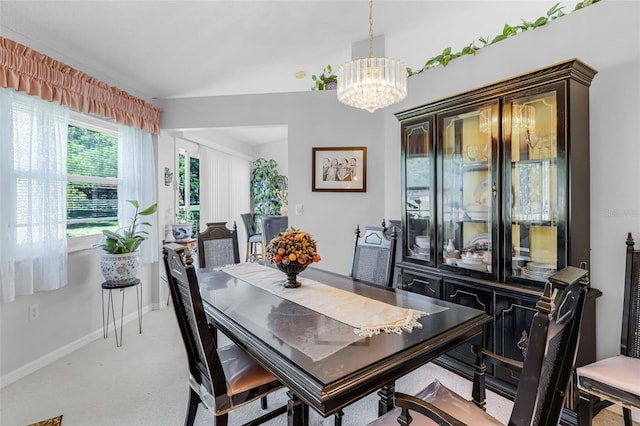 carpeted dining space with baseboards and an inviting chandelier