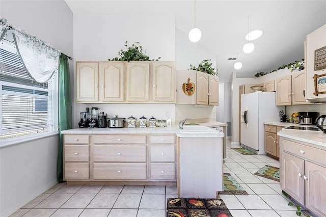 kitchen with light countertops, white refrigerator with ice dispenser, light tile patterned flooring, and light brown cabinets