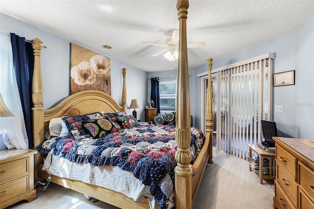 bedroom featuring light colored carpet, a textured ceiling, and ceiling fan