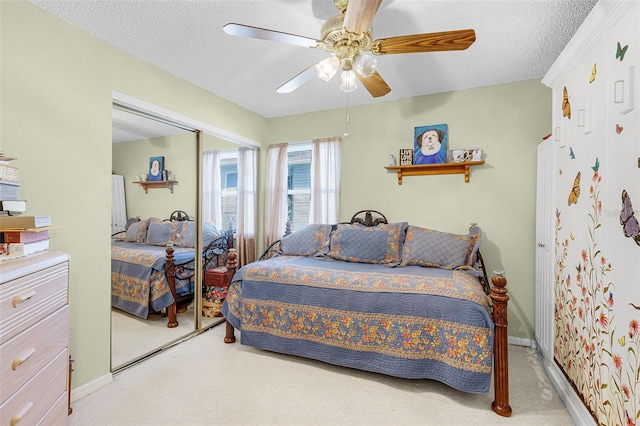 bedroom featuring carpet floors, ceiling fan, and a textured ceiling