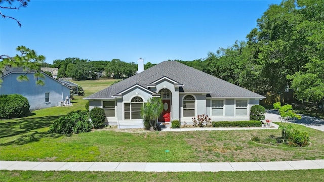 view of front of home featuring roof with shingles and a front yard