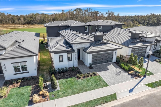 3024 Kensington Ave, Davenport, FL 33837 - view of front facade featuring a tile roof, decorative driveway, a garage, and stucco siding