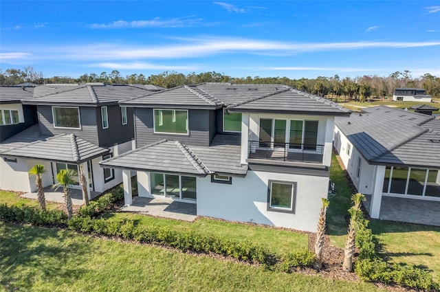 3024 Kensington Ave, Davenport, FL 33837 - back of property with a tiled roof, stucco siding, a lawn, a patio area, and a balcony